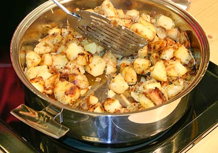 Cuisson de pommes de terre dans la sauteuse en inox