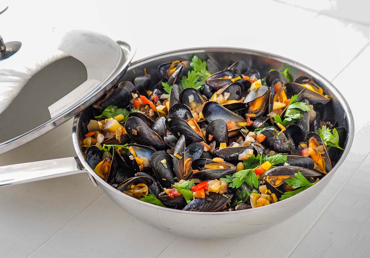 Une délicieuse recette de moules de bouchot. Elles sopnt cuites au wok dans leur garniture façon provençale.