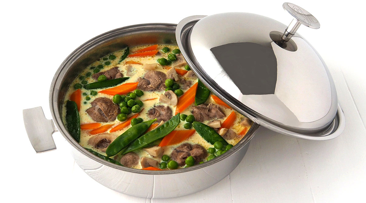 Recette de sauté de veau printanier. Ici la préparation est présentée dans la Sauteuse Cuisson Douce avec son couvercle cloche en inox.