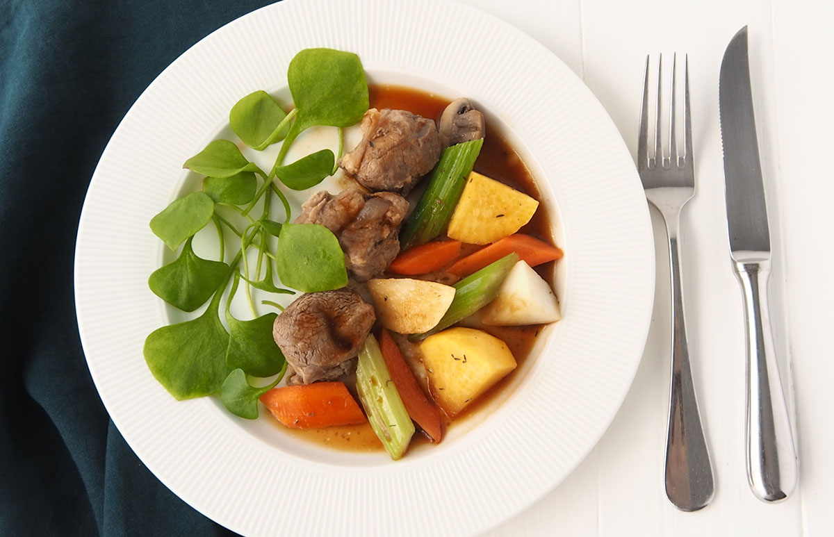 Présentation sur assiette de la recette de navarin d'agneau en cuisson douce