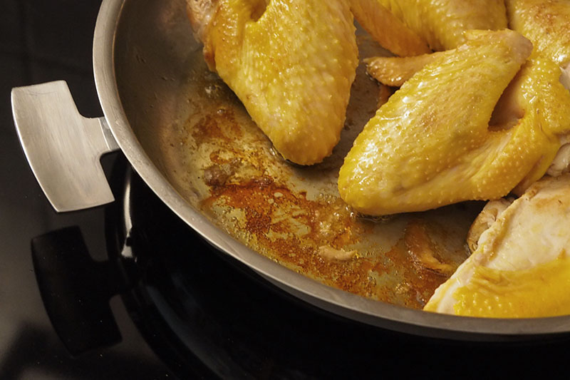 Recette de paella à l'épeautre. Première étape, on grille le poulet dans la poêle en inox