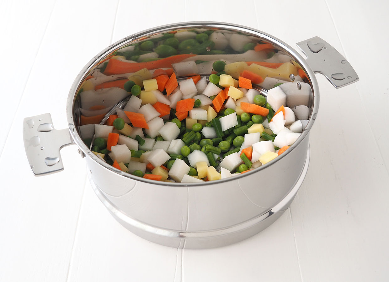 Cuisson de la macédoine de légumes dans la passoire haute