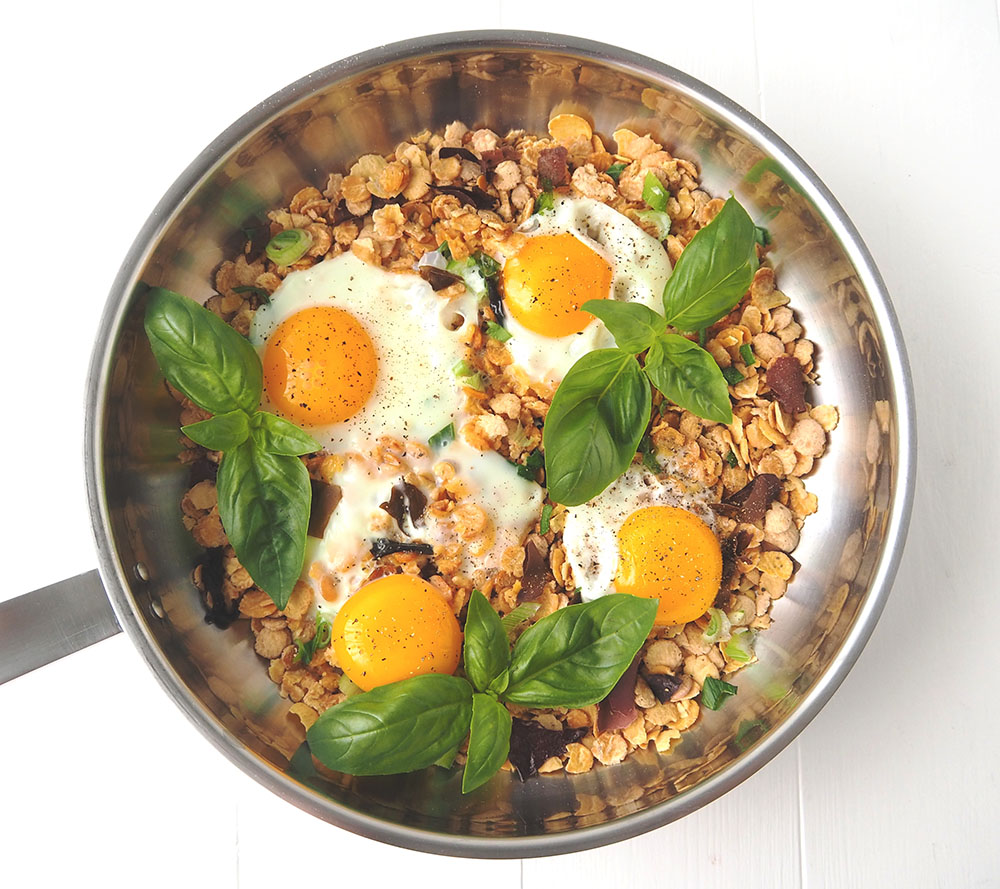 Oeufs sur lit de cereales poele Préparation de la recette d'œufs au plat sur un lit de céréales. Cuisson dans la Poêle en inox Baumstal